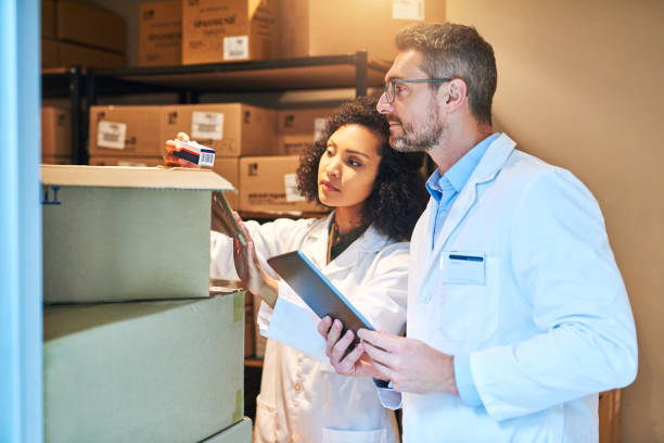 Shot of a young woman and mature woman using a digital tablet while doing inventory in a pharmacy storeroom